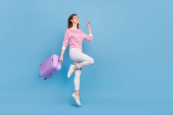 Full length profile photo of energetic overjoyed lady look empty space hold bag isolated on blue color background - Zdjęcie, obraz