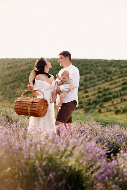 Beautiful young family in a lavender field spends the day - Fotoğraf, Görsel