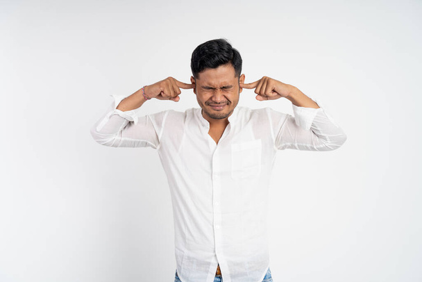 man with uncomfortable expression with fingers covering ears - Foto, Imagem