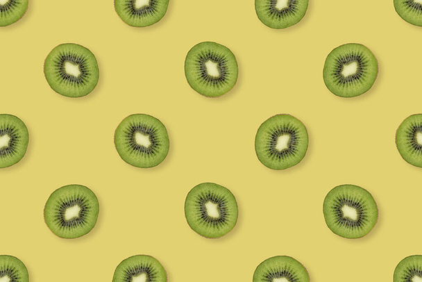 Pattern of kiwi slices. Food background. Yellow and green kiwi slices. Pattern of fresh fruits. - 写真・画像