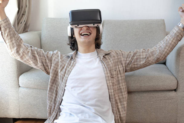 Homme portant des lunettes de réalité virtuelle joue à un jeu 3D avec excitation, Homme en lunettes de réalité virtuelle, VR, Jeux futurs, Gadgets, Technologie, Fond blanc - Photo, image