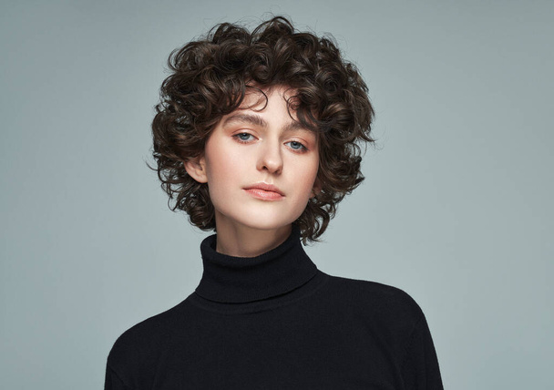 Portrait of brunette with curls wear high neck jumper isolated on grey background - Photo, Image