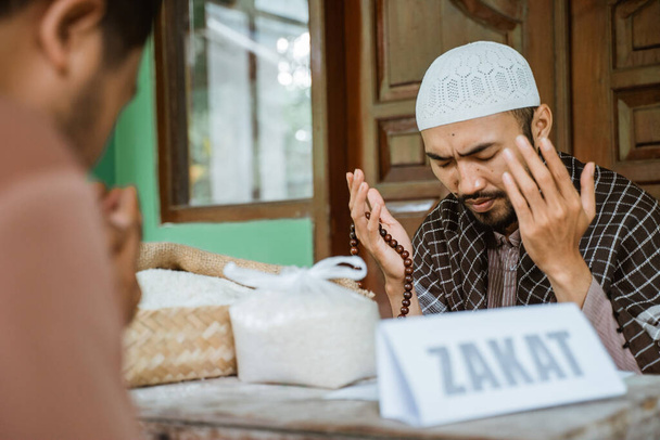 asian man paying zakat at the mosque and praying thanking god - 写真・画像