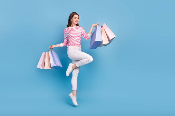 Full length photo of glad lady hold packages look empty space offer isolated on blue color background - Fotografie, Obrázek