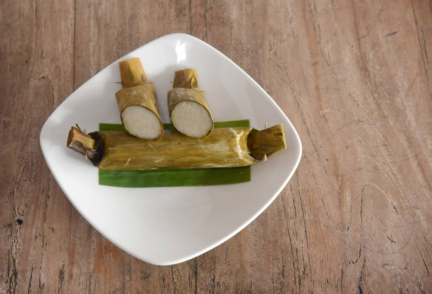 Traditional Indonesian food names "LONTONG",placed on white plate on brown wooden table - Photo, Image