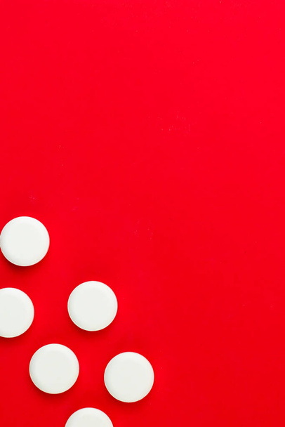 white pills on a red background. medical concept. - Foto, Imagen
