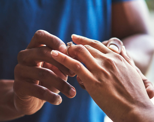 Je to oslava věčné lásky. Detailní záběr nerozpoznatelného muže, jak dává zásnubní prsten na prst své snoubenky. - Fotografie, Obrázek