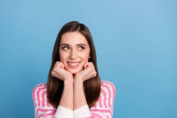 Portrait of minded positive lady hands cheeks look interested empty space isolated on blue color background - Photo, Image