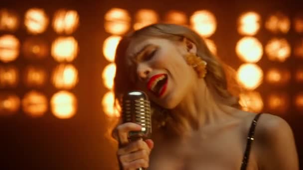 Çekici kız vokalist sahne gece kulübünde mikrofon tutarak şarkı söylüyor. - Video, Çekim