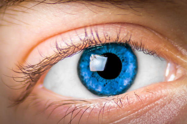 Extreme close-up van het oog van een meisje dat is gekleurd blauw en kijken naar de camera - Foto, afbeelding