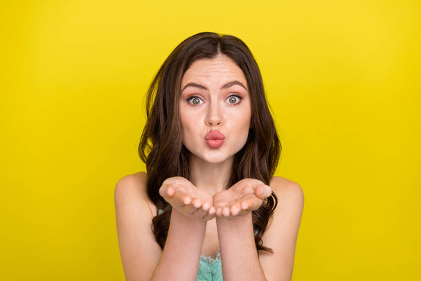 Portrait of cute adorable good mood female flirting with you send air kiss express love isolated on yellow color background - Фото, изображение