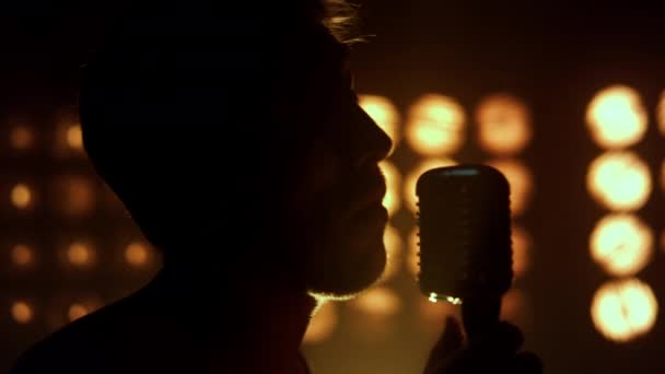 Silhouet man die liedjes zingt in nachtclub close-up. Onbekende zanger die zingt. - Video