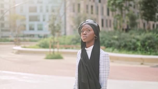Mujer musulmana admirando la calle de la ciudad soleada - Imágenes, Vídeo