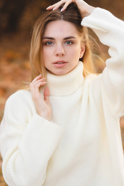 Houkutteleva blondi valkoisessa puserossa syksyn värien taustalla - Valokuva, kuva