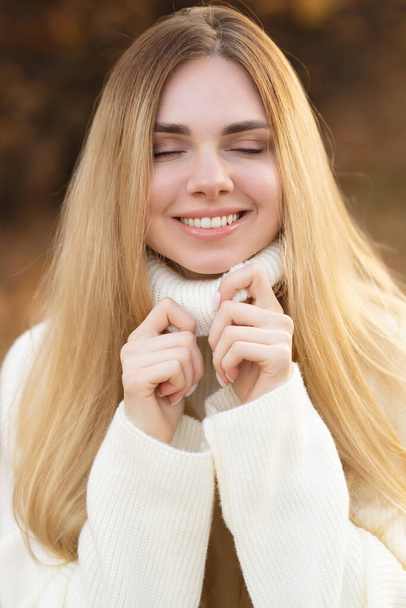 Привлекательная блондинка в белом свитере на фоне осенних красок - Фото, изображение