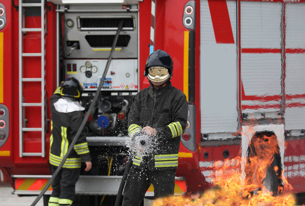 訓練中の消防士は背後の消防車と消防車を消火し - 写真・画像