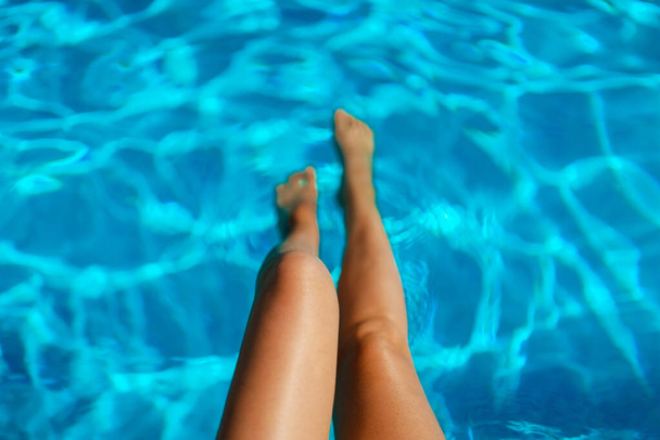 Dişi bacaklar. Havuzun kenarında oturan kadın.. - Fotoğraf, Görsel