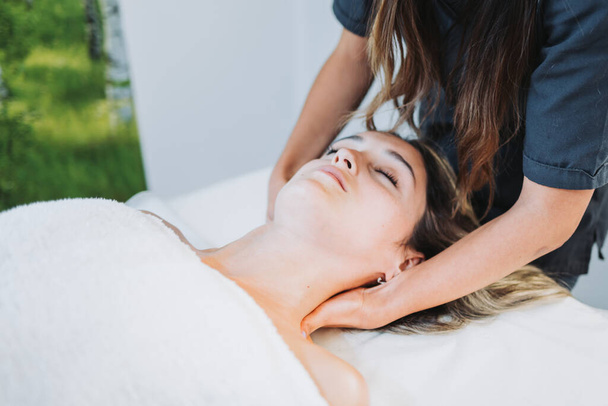 Thérapeute féminine faisant un massage du cou à une patiente face visible. Centre de bien-être spa. Soins de la peau. - Photo, image