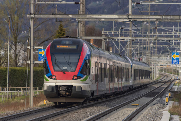 Червоний швидкісний поїзд біля міста Беллінцони, що на півдні Швейцарії. - Фото, зображення