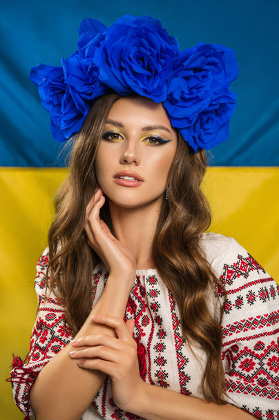 愛国的なメイクと青の花輪を持つ美しいウクライナ人女性 - 写真・画像