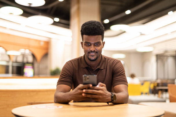 Portrait of young handsome black man at coffee shop - Foto, afbeelding