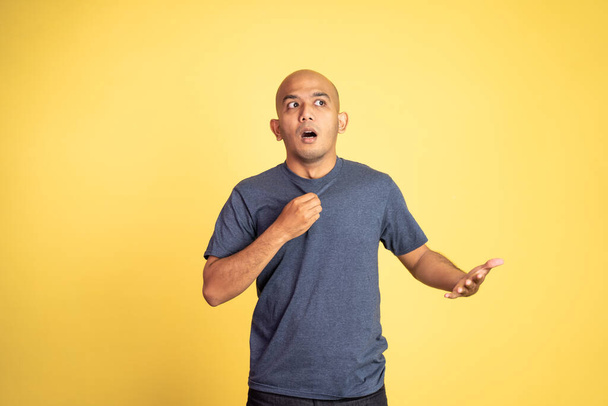 shocked asian bald man with astonished expression on isolated background - Foto, afbeelding