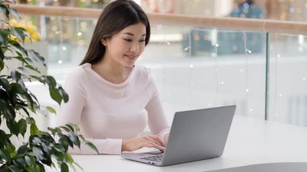 Ázsiai lány diák koreai üzleti nő szabadúszó író újságíró ül cafeteria kávézó az irodában laptoppal gépelés foglalások kirándulások segítségével ingyenes wi-fi dolgozik tanul számítógépes alkalmazás - Felvétel, videó