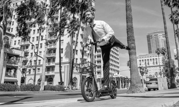 Straßenerholung. Glückliche Arbeitgeber fahren escooter auf dem Bürgersteig. E-Scooting für Freizeit und Spaß - Foto, Bild