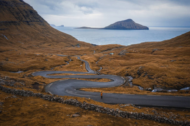 Aerial view on serpentine road on the island Streymoy near the village Nordradalur with view of Koltur island. Faroe Islands, Denmark. November 2021 - Photo, Image