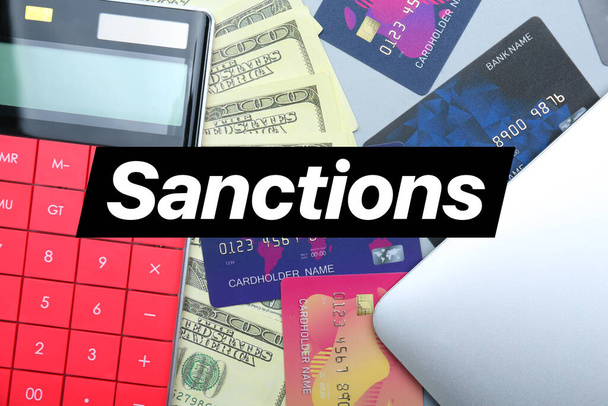 Kreditkarten mit Geld, Taschenrechner und Laptop auf dem Tisch. Sanktionskonzept - Foto, Bild