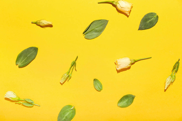 Güzel Eustoma çiçekleri ve sarı arka planda yapraklar - Fotoğraf, Görsel