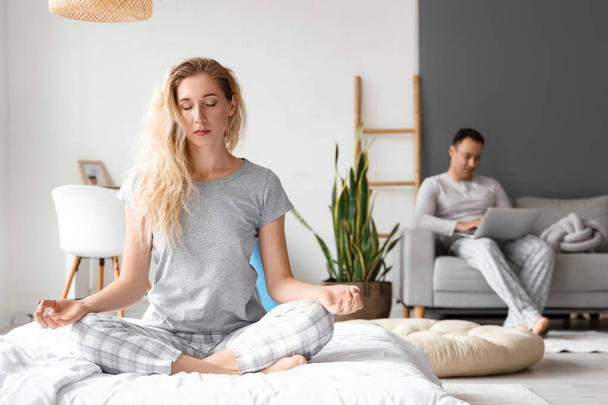 Beautiful woman meditating in bedroom at home - Photo, Image