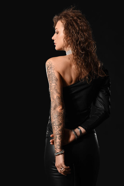 Gyönyörű divatos tetovált nő fekete háttér - Fotó, kép