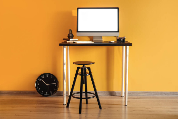 Kényelmes munkahely számítógép közelében színes fal - Fotó, kép