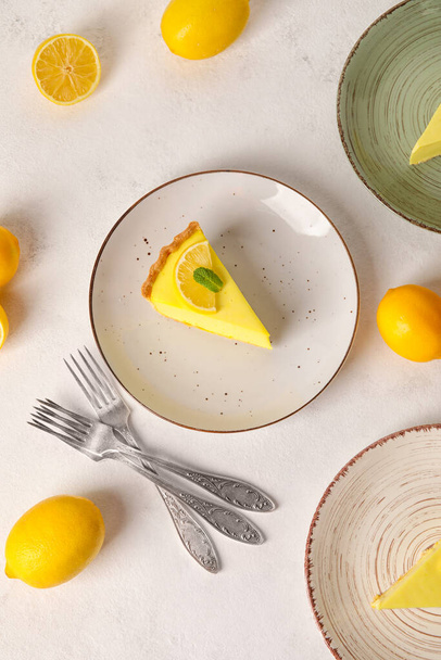 Lemezek ízletes citromos pitével és friss gyümölcsökkel fehér alapon - Fotó, kép