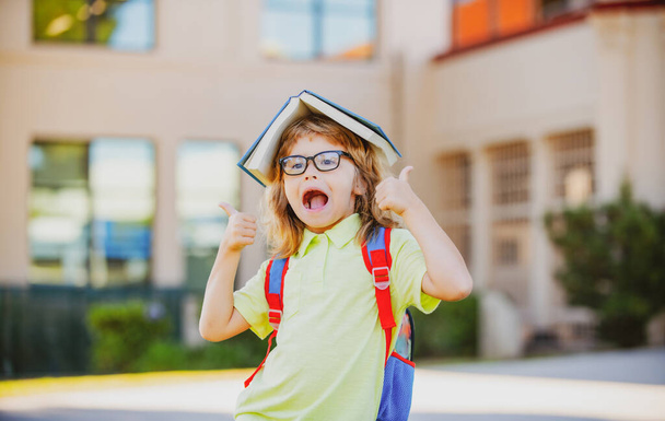 Happy smiling kid in glasses is going to school for the first time. Pupil go study. Child boy with bag go to elementary school. Child of primary school. Back to school. Kids education concept. - Zdjęcie, obraz