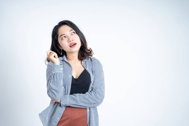 Young asian woman thinking something side copyspace on isolated background - Fotoğraf, Görsel