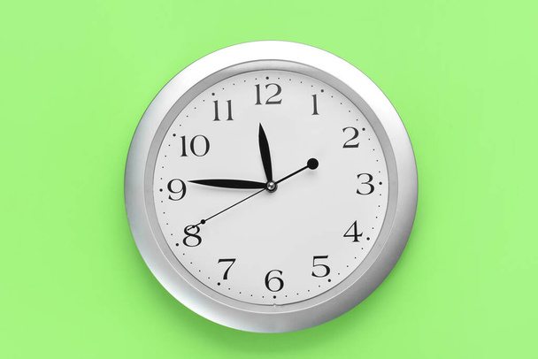 New modern clock on green background - Fotoğraf, Görsel