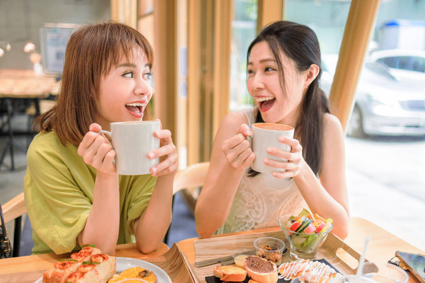 Felice giovani donne che bevono caffè in caffetteria - Foto, immagini