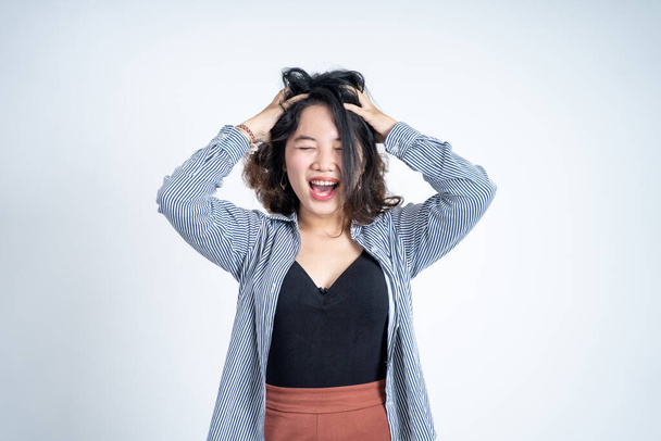 Asiática joven sosteniendo la cabeza con dolor de cabeza en aislado fondo - Foto, imagen