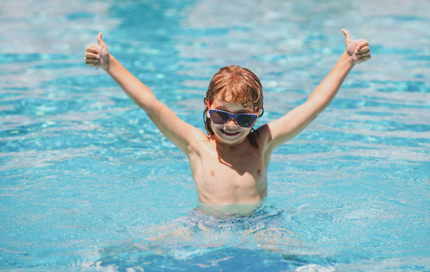 Excited little child boy in sunglasses in pool in summer day. Child boy swim in swimming pool. - Zdjęcie, obraz