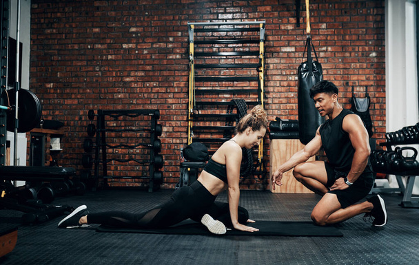 Hes helping me to live healthier. Shot of a young woman working out with her personal trainer. - Photo, Image
