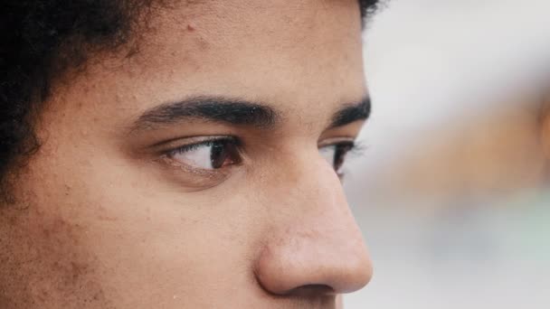 Visão lateral close-up cara triste masculino em detalhes perfil olhos afro-americano homem pensativo cara olhando para a distância para o lado pensando esperando atender visão oftalmológico serviço acne pele problemas - Filmagem, Vídeo