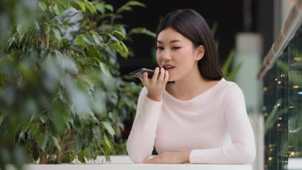  Asijské korejština obchodní žena dívka nahrávání hlasu rozpoznávání zprávy na reproduktorphone dáma žena v kavárně pomocí virtuální asistent app připomínka na telefonu sedí u stolu použití digitální mobilní pomoc - Záběry, video