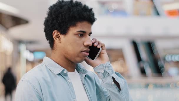 Muotokuva korosti afrikkalainen mies kuulee kauheita uutisia matkapuhelin puhelu konflikti stressi riitaa tyttöystävä kauko keskustelua. Tyytymätön kaveri vihainen väärinkäsitys ongelma puhuu älypuhelin sisätiloissa - Materiaali, video