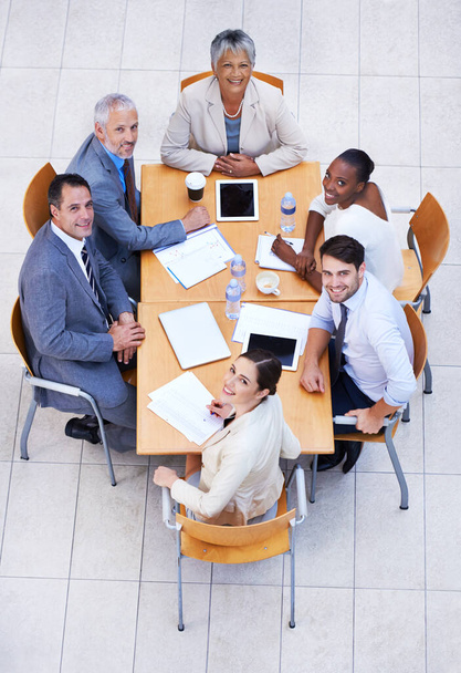 Uitvoerende besluitvorming. Hoge invalshoek van een groep zakenmensen die vergaderen aan een vergadertafel. - Foto, afbeelding