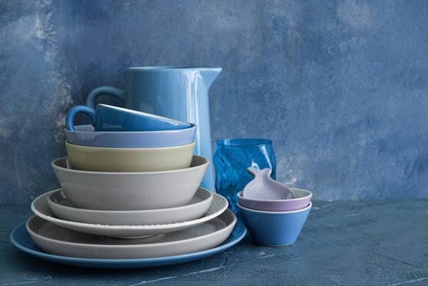 Set of beautiful dinnerware on blue grunge background - Photo, Image