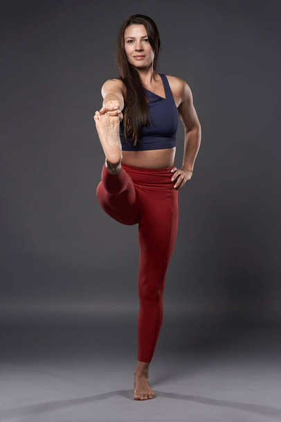 Woman yoga trainer in Utthita Hasta Padangusthasana pose - Valokuva, kuva