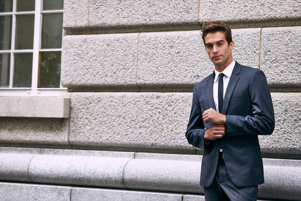 The lifestyle of a businessman. Portrait of a handsome businessman in a suit standing outside a city building. - Fotó, kép