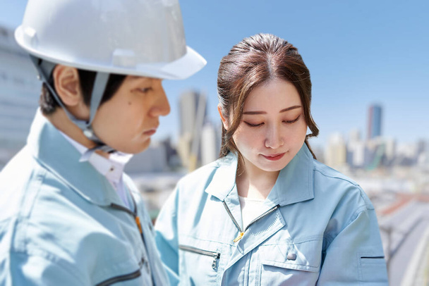 Trabajadores asiáticos teniendo una reunión en el sitio de construcción - Foto, imagen